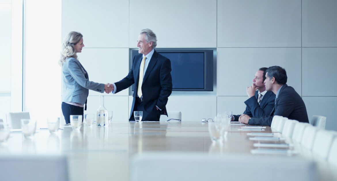 Business people shaking hands in conference room