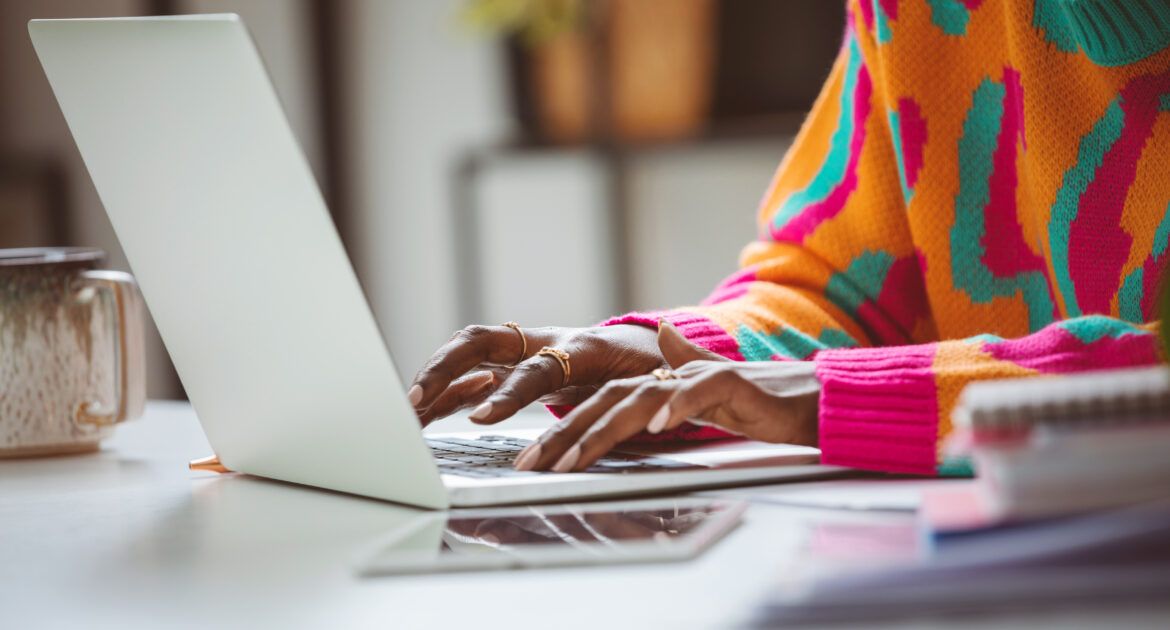 Woman typing on laptop writing job advert