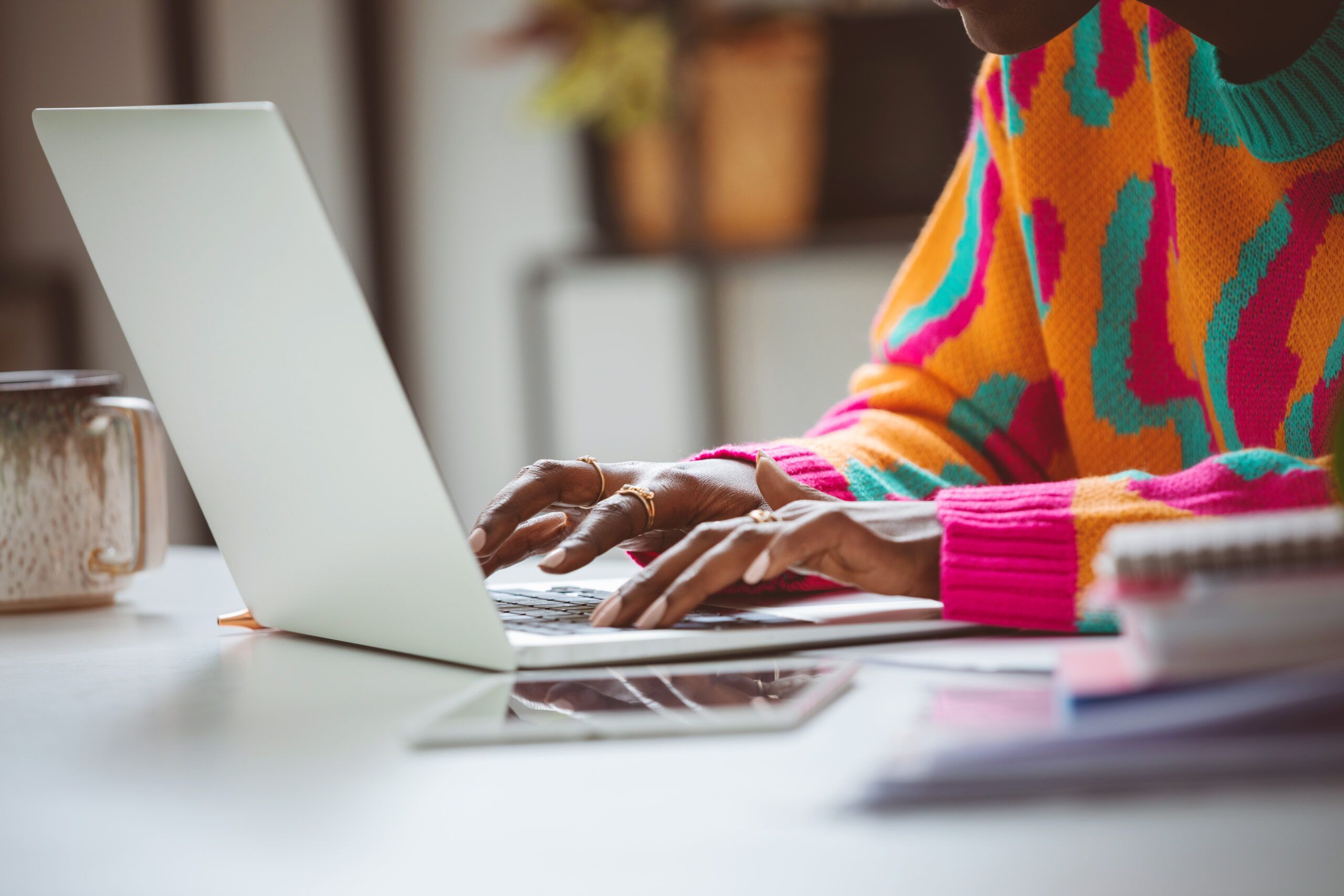 Woman typing on laptop writing job advert